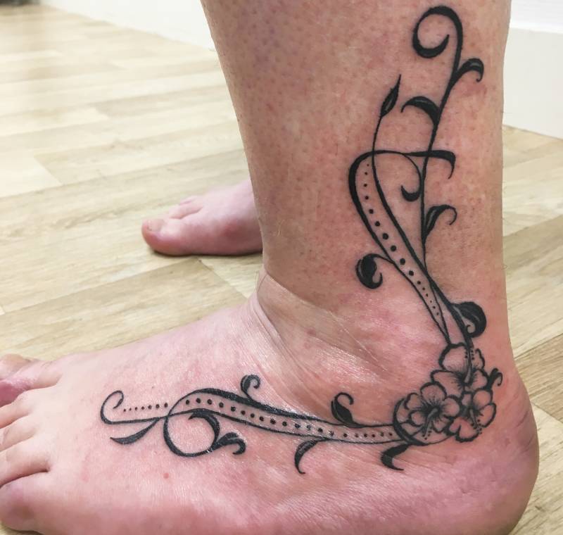 tatouage femme arabesque fleur pied